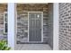 Elegant front entrance showcasing a stone pillar, a gray brick wall, and a gray front door at 6235 Banyan Trl, Cumming, GA 30028