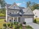 Charming home featuring a brick front, gray siding, and a covered front porch at 6235 Banyan Trl, Cumming, GA 30028
