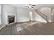 Inviting living room featuring hardwood floors, a fireplace, and staircase for entertainment at 6235 Banyan Trl, Cumming, GA 30028