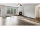 An open-concept living room with hardwood floors, a cozy fireplace, and abundant natural light at 6235 Banyan Trl, Cumming, GA 30028