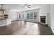 Spacious living area with hardwood floors, a fireplace, and an adjacent kitchen with modern appliances at 6235 Banyan Trl, Cumming, GA 30028