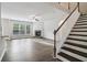 Bright and airy living room featuring hardwood floors, a fireplace, and staircase to the second floor at 6235 Banyan Trl, Cumming, GA 30028