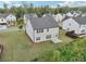 Exterior shot of home's rear, featuring a large, grassy lawn and a concrete patio at 6235 Banyan Trl, Cumming, GA 30028