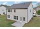 Exterior shot of home's rear, featuring a large, grassy lawn and a concrete patio at 6235 Banyan Trl, Cumming, GA 30028