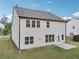 Exterior shot of home's rear, featuring a large, grassy lawn and a concrete patio at 6235 Banyan Trl, Cumming, GA 30028