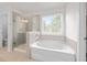 Beautiful bathroom featuring a separate shower and a large soaking tub with a window at 6701 Cedar Glen Rd, Peachtree Corners, GA 30071