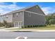 A two-story townhouse boasts a gray exterior and a two-car garage door, surrounded by a green lawn at 6701 Cedar Glen Rd, Peachtree Corners, GA 30071