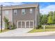 A two-story townhouse boasts a gray exterior and a two-car garage door, surrounded by a green lawn at 6701 Cedar Glen Rd, Peachtree Corners, GA 30071