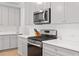 Contemporary kitchen featuring stainless steel appliances, white countertops, and sleek gray cabinets at 6701 Cedar Glen Rd, Peachtree Corners, GA 30071