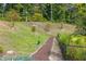 Winding mulch path along a grassy hill, bordered by trees and greenery at 6701 Cedar Glen Rd, Peachtree Corners, GA 30071