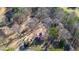 Aerial view of home, adjacent outbuildings and treed lot at 436 Tarpley Ave, Bowdon, GA 30108