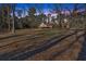Beautiful backyard view with mature trees and distant house with deck at dusk at 436 Tarpley Ave, Bowdon, GA 30108