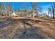Spacious yard with trees leads to a house with a wooden deck, set against a clear sky at 436 Tarpley Ave, Bowdon, GA 30108