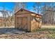 A small, wooden outbuilding features a double-door entry and appears to be a storage shed at 436 Tarpley Ave, Bowdon, GA 30108