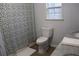 Bathroom featuring a floral shower curtain, toilet, and vanity with faux marble countertop at 823 Mount Tabor Rd, Oxford, GA 30054