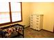 A cozy carpeted bedroom with a game table and a vintage dresser by the window at 823 Mount Tabor Rd, Oxford, GA 30054