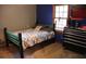 Bedroom with unique bed frame, carpet, and blue accent wall with natural light at 823 Mount Tabor Rd, Oxford, GA 30054