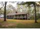 Single-story home on wooded lot features a covered porch, gray siding, and orange window shutters at 823 Mount Tabor Rd, Oxford, GA 30054
