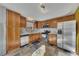 Well-lit kitchen with stainless steel appliances, wood cabinets and stone tile floors at 920 Pine Grove Pointe Dr, Roswell, GA 30075
