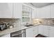 Modern kitchen with white cabinets, stainless steel appliances, and gray granite countertops at 1684 Braeburn Se Dr, Atlanta, GA 30316