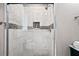 Walk-in shower featuring marble tile with a glass enclosure and built-in niche at 1684 Braeburn Se Dr, Atlanta, GA 30316