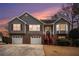 Charming two-story home featuring gray siding, brick accents, and a well-manicured lawn at sunset at 2901 Soapstone Ct, Powder Springs, GA 30127