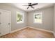 Bright bedroom with hardwood floors, two windows, ceiling fan, and white door at 1208 Thomas Rd, Decatur, GA 30030