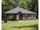 Charming single-story home with stone and wood siding, well-maintained lawn, and wooded backdrop at 1208 Thomas Rd, Decatur, GA 30030