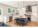Modern kitchen boasts white cabinets, gray island, stainless appliances, and stylish pendant lighting at 1208 Thomas Rd, Decatur, GA 30030
