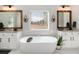 Bright bathroom with a soaking tub, dual sinks, granite countertops, and decorative mirrors at 263 Osier Dr, Mcdonough, GA 30252