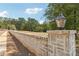 Elegant stone wall with classic gas lanterns enhances the curb appeal of this charming community at 4415 Natchez Ln, Cumming, GA 30040