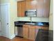 Well-maintained kitchen with stainless steel appliances, wood cabinets, and black countertops at 57 Forsyth Nw St # 4H, Atlanta, GA 30303