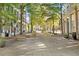 Exterior view of a lively, tree-lined town square with tables and street lamps at 57 Forsyth Nw St # 4H, Atlanta, GA 30303
