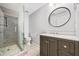 Modern bathroom with a glass-enclosed shower, grey vanity, and a stylish round mirror at 2833 Landing Way, Marietta, GA 30066