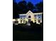 Beautiful two-story home featuring a brick facade, symmetrical windows, and manicured landscaping illuminated at night at 2833 Landing Way, Marietta, GA 30066