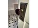 Closeup of decorative doorknob leading to bathroom with tiled floor and white tub at 1763 Mercer Ave, Atlanta, GA 30337