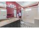 This bathroom features a sink with decorative vanity, a window, toilet and tiled shower at 1763 Mercer Ave, Atlanta, GA 30337