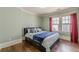 Bedroom with hardwood floors and two windows adorned with elegant red curtains for added privacy at 1763 Mercer Ave, Atlanta, GA 30337