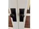 Close up of white french doors with decorative, vintage black hardware and dark wood floors at 1763 Mercer Ave, Atlanta, GA 30337