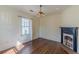 Living room with hardwood floors, large window with curtains, fireplace, and white walls at 1763 Mercer Ave, Atlanta, GA 30337