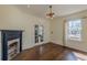 Sunlit living room with decorative fireplace, hardwood floors, and access to porch through french doors at 1763 Mercer Ave, Atlanta, GA 30337