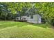 Wide view of backyard with a manicured lawn, back deck, and seating surrounding the fire pit at 3314 Creatwood Se Trl, Smyrna, GA 30080