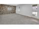 Spacious finished basement featuring stone accent wall and plush carpeting at 6640 Grove Crossing Ct, Cumming, GA 30028