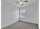 A bedroom with neutral carpet, ceiling fan, and window, offering a cozy and adaptable space at 6640 Grove Crossing Ct, Cumming, GA 30028