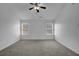Large bedroom featuring neutral walls and carpet, two windows, and a ceiling fan, creating a serene retreat at 6640 Grove Crossing Ct, Cumming, GA 30028