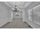 Spacious dining room with tray ceiling, chandelier, and large windows at 6640 Grove Crossing Ct, Cumming, GA 30028
