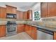 Well-lit kitchen featuring stainless steel appliances and granite countertops at 6640 Grove Crossing Ct, Cumming, GA 30028