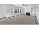 Spacious living room with fireplace, fan, and large windows offering ample natural light at 6640 Grove Crossing Ct, Cumming, GA 30028