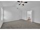 Airy main bedroom featuring neutral carpet, a ceiling fan, and an ensuite bathroom with ample space at 6640 Grove Crossing Ct, Cumming, GA 30028