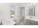 Bathroom with vanity, mirror, and window, offering view of the neighborhood at 1861 Lacebark Elm Way, Lawrenceville, GA 30045